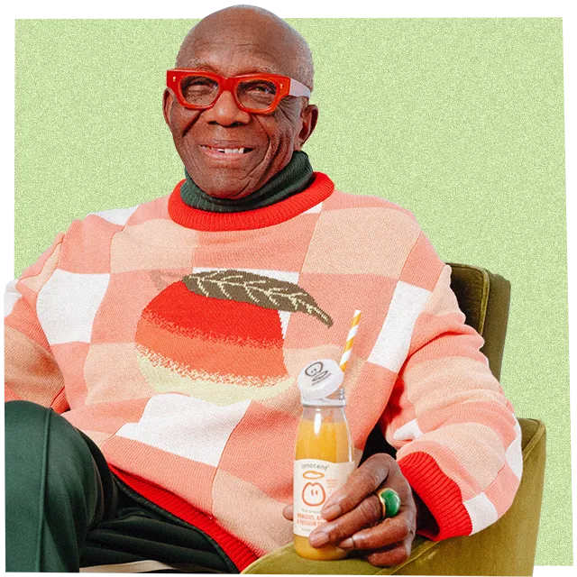 Mann trägt einen großen Strickpullover und trinkt einen innocent Smoothie